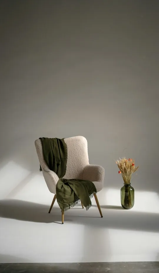 Poltrona com manta verde em ambiente acolhedor